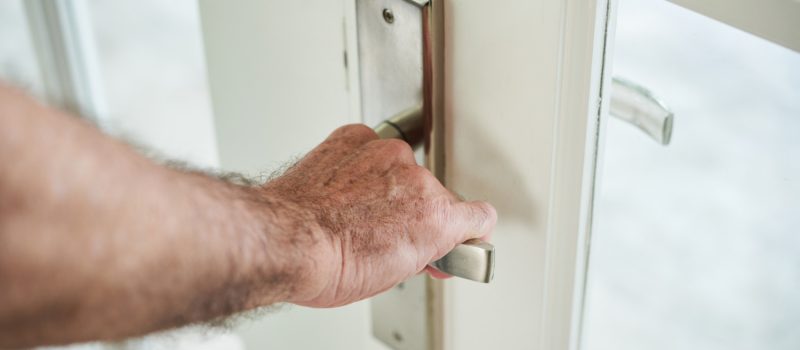 cropped-anonymous-man-holding-door-handle-open-door