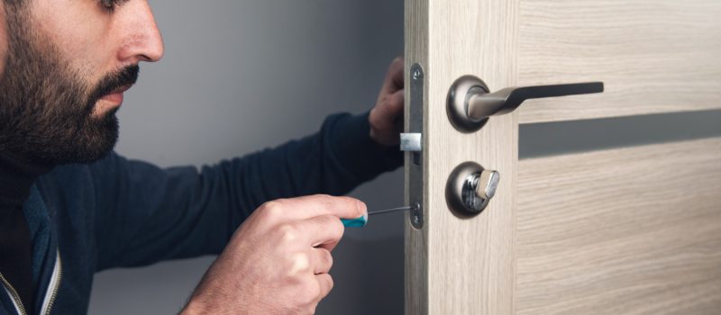 man-repairing-door-handle-with-screwdriver